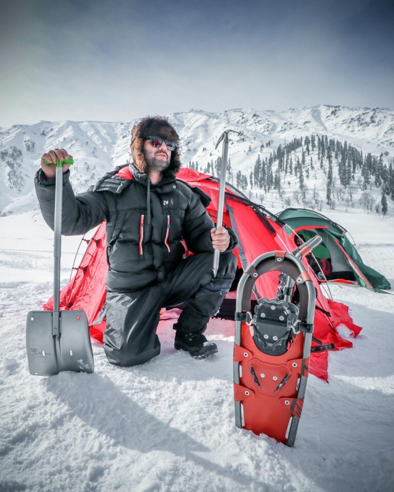 A man adventuring in Gulmarg with snow gear and tents during winter.