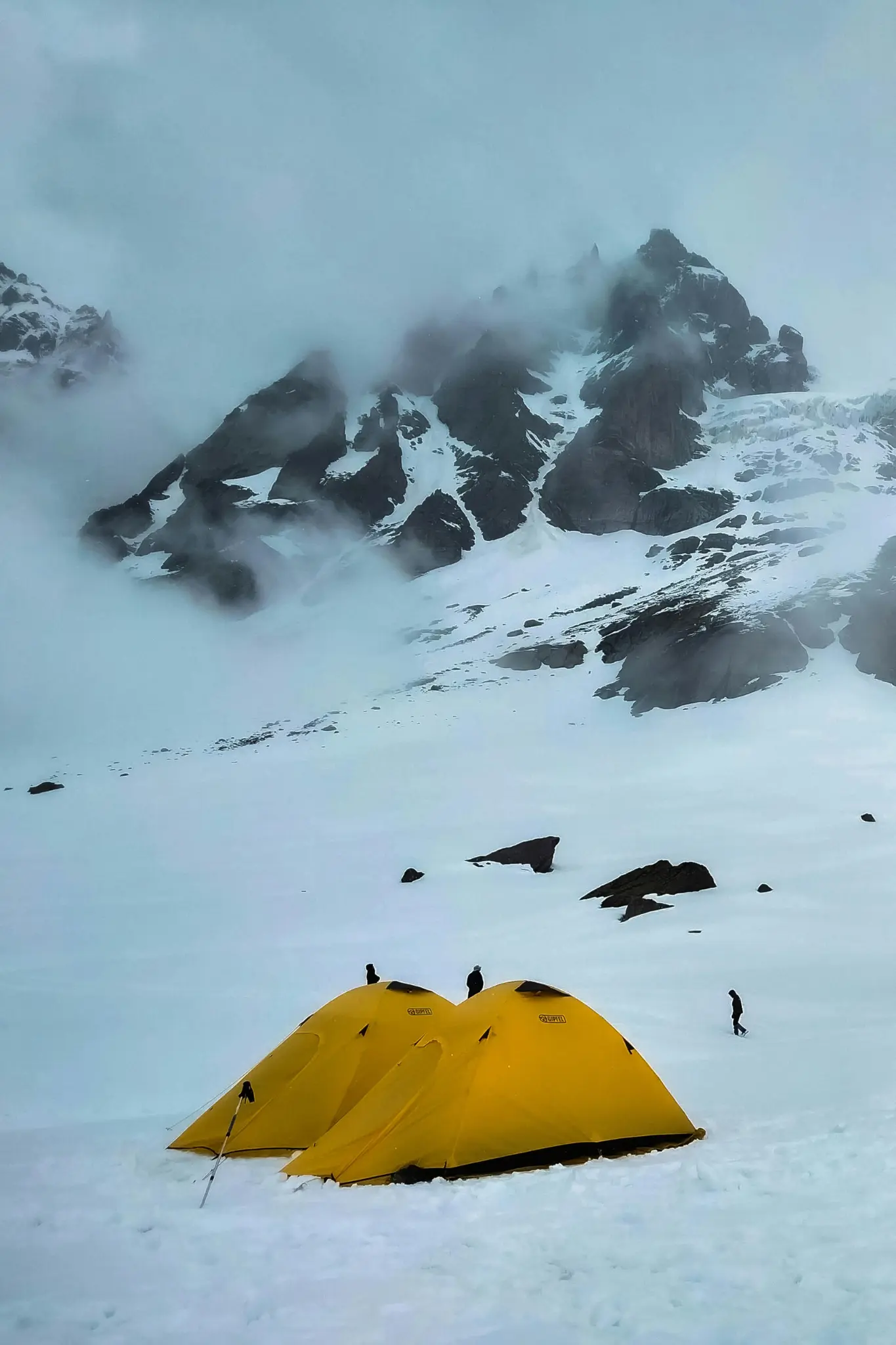 High-altitude tents set up in snowy Himalayan landscape