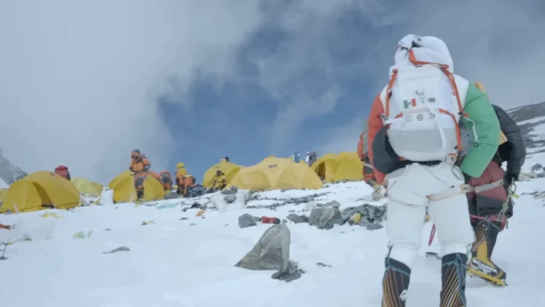 Bright yellow mountaineering tents set up on the snowy slopes of Everest, with climbers preparing for extreme high-altitude conditions. Perfect tents for harsh weather.