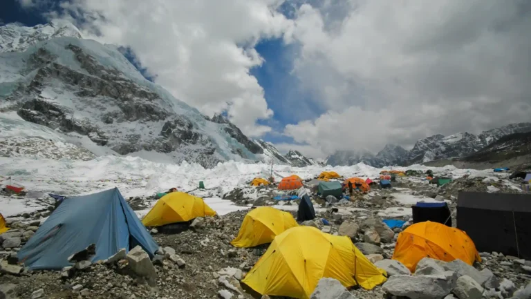 Everest Base Camp with yellow and blue tents pitched on rocky terrain under snowy mountain peaks, showcasing the best Everest Base Camp tents for extreme weather.