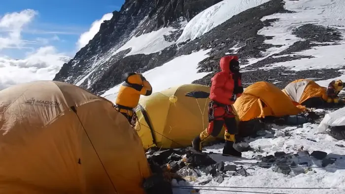 Climbers setting up high-altitude expedition tents on a rugged, snow-covered mountainside at Everest, showcasing the best Everest tents for extreme weather conditions.